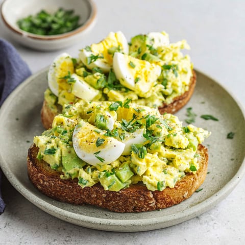 Two pieces of toast with avocado and egg salad.