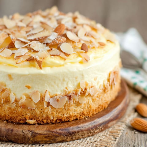 A slice of cake with almonds on top.
