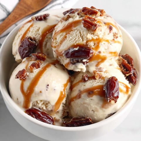 A bowl of ice cream with caramel drizzled on top.