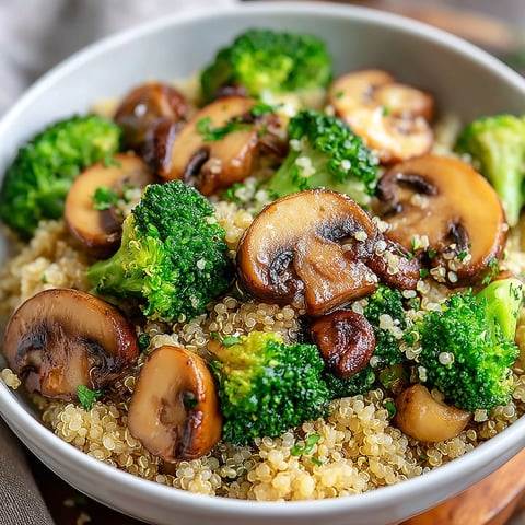 A bowl of creamy quinoa with mushrooms and broccoli.