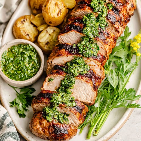 A pork tenderloin with chimichurri sauce.