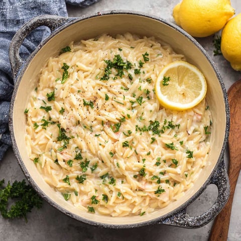 A bowl of pasta with lemon wedges on top.