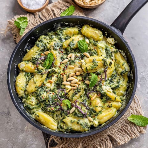 A black skillet with a green vegetable dish.